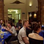Participants sitting round tables at the EU Pub Café event at the Natural History Museum